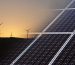 A landscape view of Green energy sources with wind turbines in the background and solar panels in the foreground at sunset.